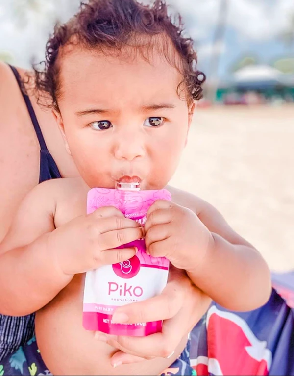 A baby eating from a Pitaya Bowl Piko Provisions pouch