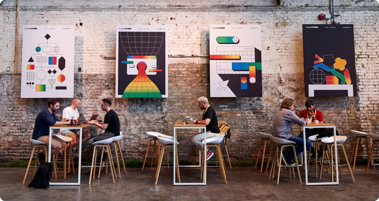 Custom posters created for Google I/O Connect, on display in a warehouse coffee shop.